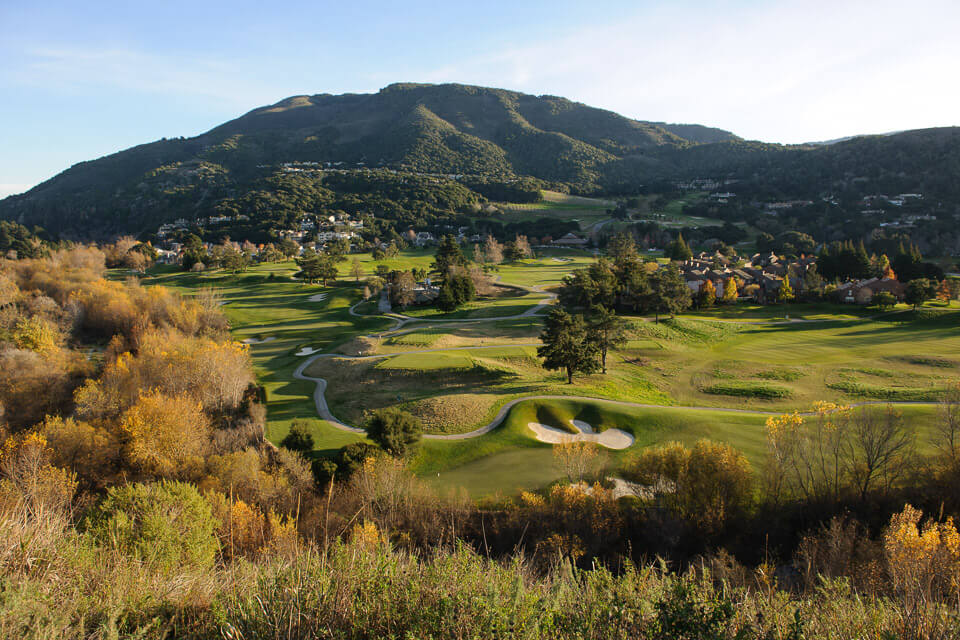 This is an image of the golf course and property of Carmel Valley Ranch with trees and mountains in the background