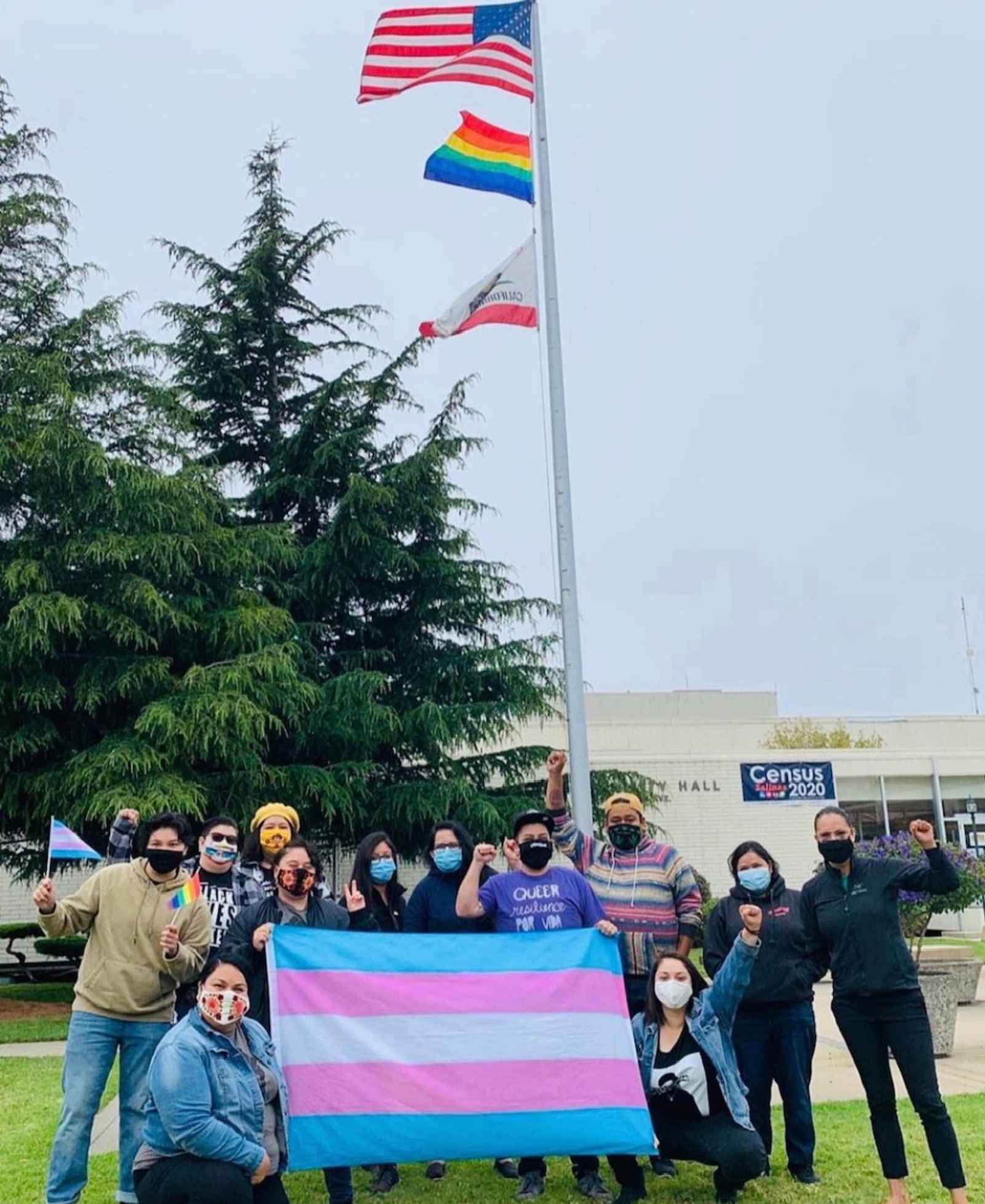 A group of people holding a pride flag