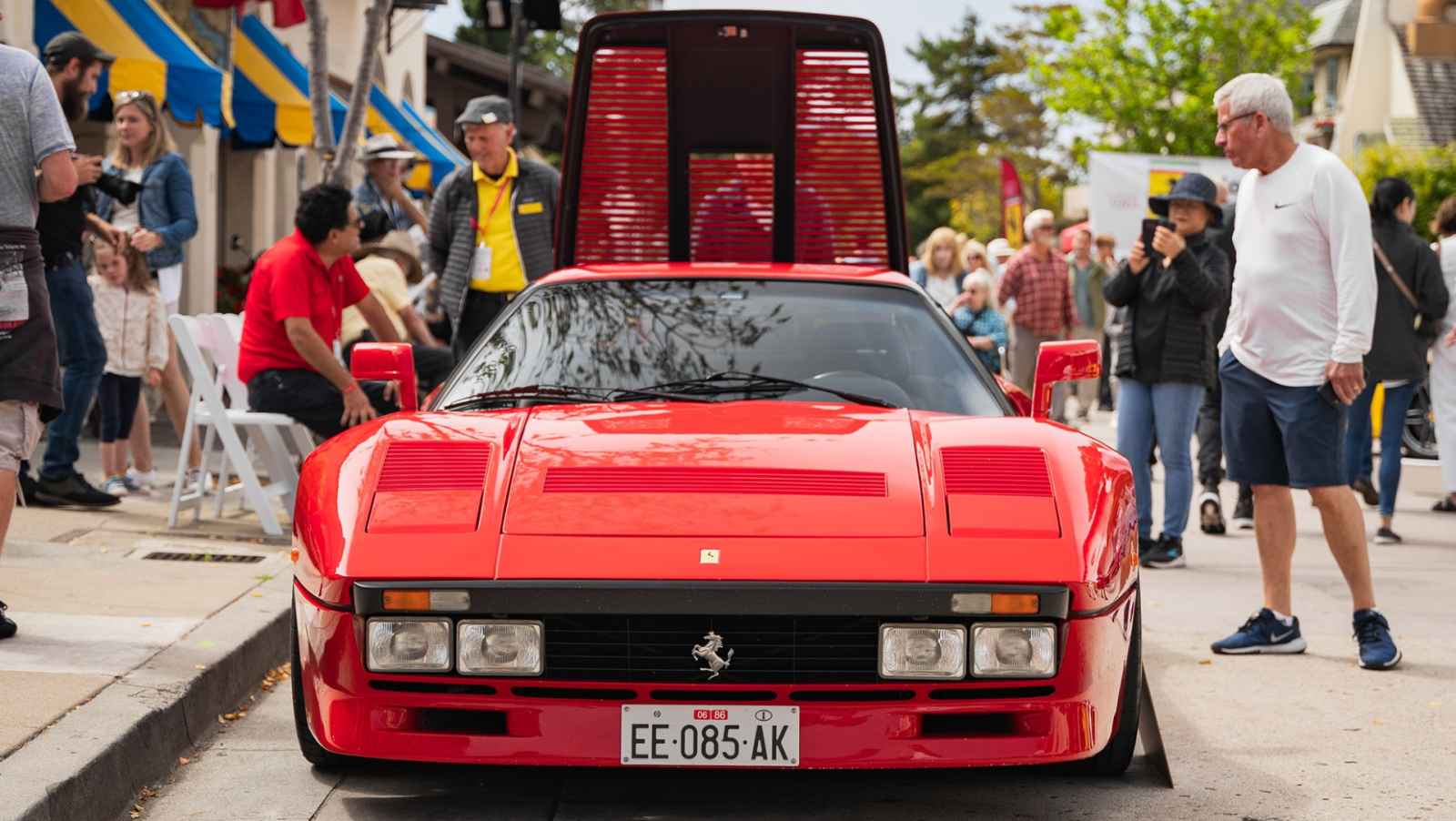 This is an image of a red classic ferrari on display at Monterey Car Week