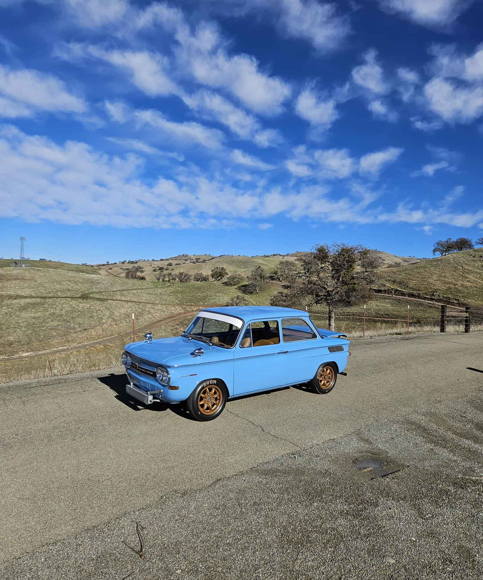 This is an image of a little blue classic car for display at The Little Car Show at Monterey Car Week