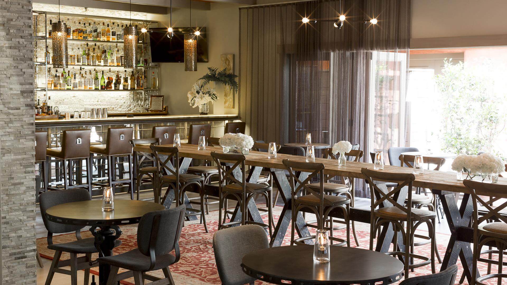 Interior dining area of Lucia Restaurant and Bar at Bernardus Lodge & Spa in Carmel Valley set with tables and chairs