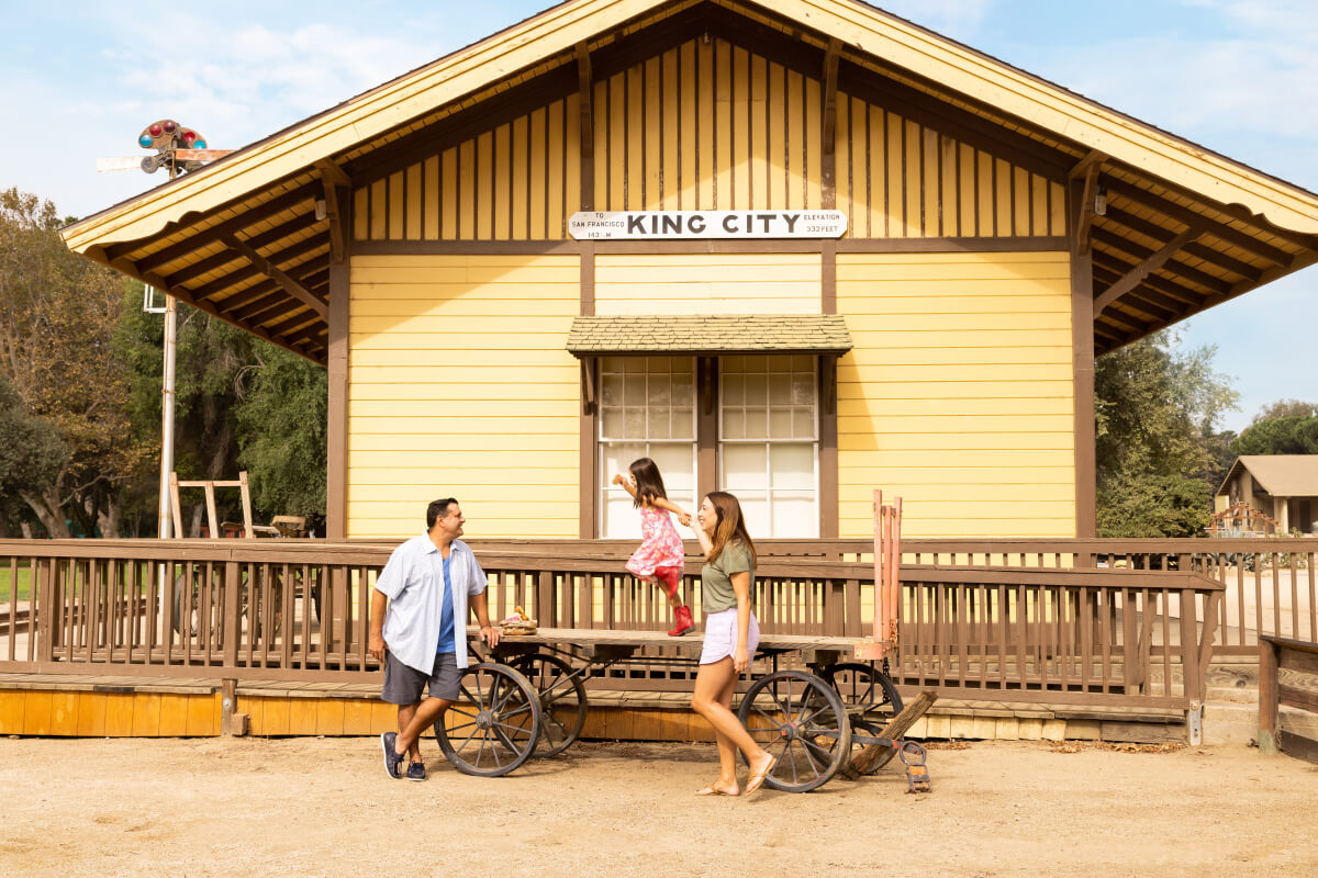 This is an image of a family outside of the bright yellow building of the Agricultural and Rural Life Museum in King City, California