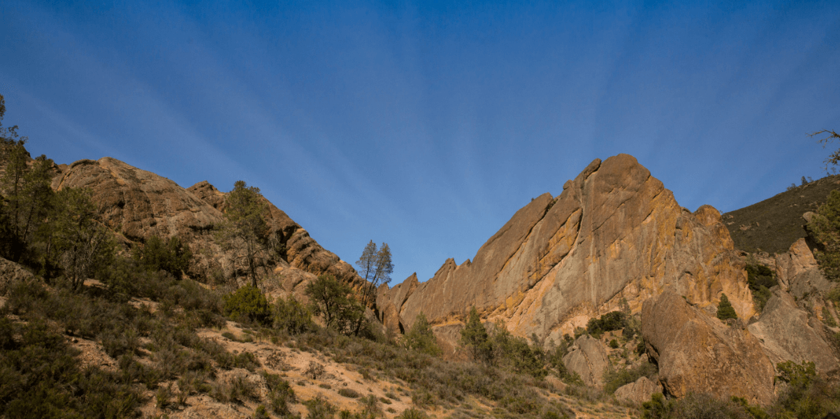 This is an image of Pinnacles National Park. The rocks are in formation and there is a bright blue sky