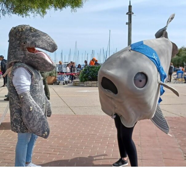 This is an image of two costumed sea creatures standing in front of Old FIsherman's Wharf in Monterey, California for Whalefest Monterey event